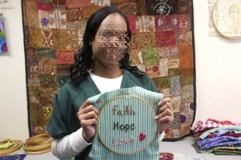 Woman posing with faith hope love embroidery